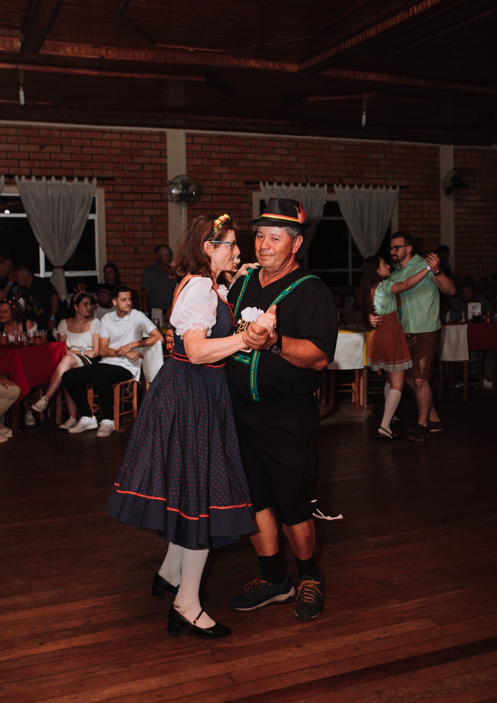 Casal dançando no salão do Clube Floresta durante o Baile Alemão